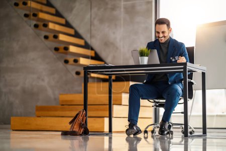 Téléchargez les photos : Homme d'affaires en costume travaillant dans un bureau moderne. Image d'entrepreneur prospère sur son lieu de travail. - en image libre de droit