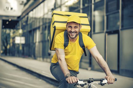 Foto de Entrega a domicilio, comida y personas concepto-feliz repartidor sonriente hombre con bolsa térmica y bicicleta en la calle de la ciudad. - Imagen libre de derechos