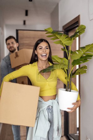 Photo for Young couple holding cardboard boxes,they are moving to a new home.Young family moving to a new apartment. - Royalty Free Image