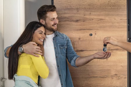 Photo for Happy  couple taking their new house key from home seller on moving day.House ownership concept. - Royalty Free Image