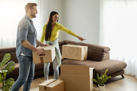 Photo for Happy young married couple moves to new apartment and unpaking boxes.Smiling couple unpaking boxes  in new home. - Royalty Free Image
