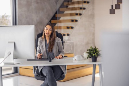 Téléchargez les photos : Femme d'affaires confiante travaillant sur ordinateur portable à son lieu de travail au bureau moderne. Concept d'entreprise, de personnel et de technologie. - en image libre de droit