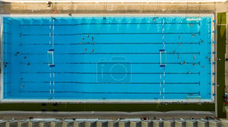 Top down view of public swimming pool.  Water polo team practicing. Artistic swimming practicing 