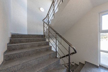 Modern stair case between floors. Stairs with metallic rail  in modern building