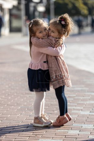 Téléchargez les photos : Deux petites filles soeurs câlins. Joyeux drôle fille sœurs étreignant et riant - en image libre de droit