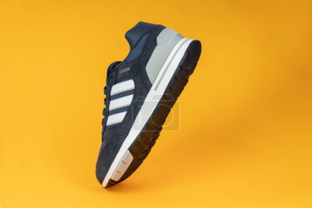 Photo for Varna , Bulgaria - AUGUST 26, 2021 : ADIDAS RETRO 80 sport shoe, yellow background. Product shot. Adidas is a German corporation that designs and manufactures sports shoes, clothing and accessories - Royalty Free Image