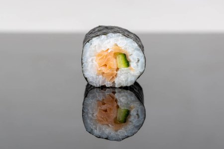 Téléchargez les photos : Sushi roll with salmon and avocado. Sushi with reflection. Traditional japanese food - en image libre de droit