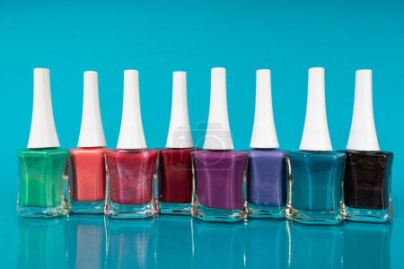 Foto de Group of bright nail polishes on a blue background - Imagen libre de derechos