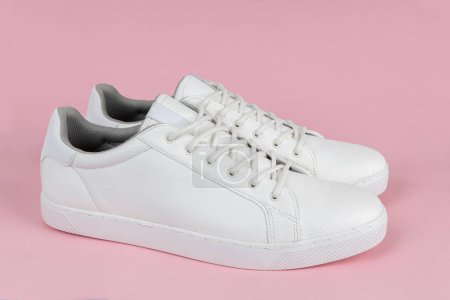 Foto de Par de nuevas zapatillas blancas sobre fondo rosa - Imagen libre de derechos
