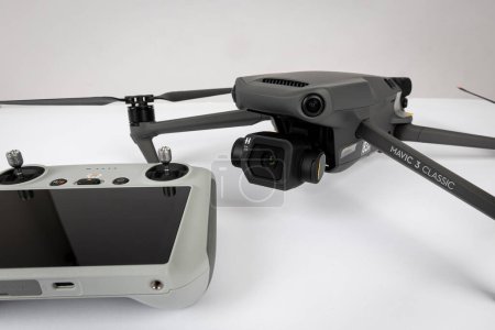 Téléchargez les photos : Varna, Bulgarie - 18 novembre 2022 : Un nouveau drone et télécommande DJI Mavic 3 CLASSIC. Quadcopter drone avion avec appareil photo numérique. Drone aérien à télécommande moderne. - en image libre de droit