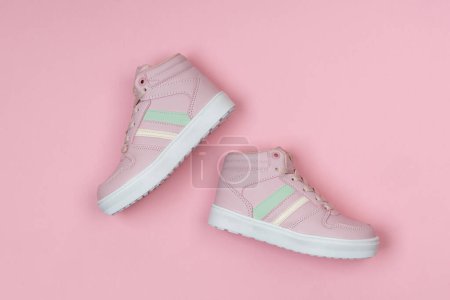 Photo for Cute pink sport shoes on pink background - Royalty Free Image