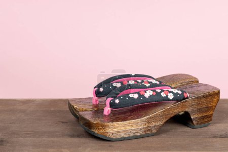 Foto de Sandalia geta tradicional japonesa sobre fondo rosa. Calzado tradicional japonés de madera asiático llamado Geta - Imagen libre de derechos