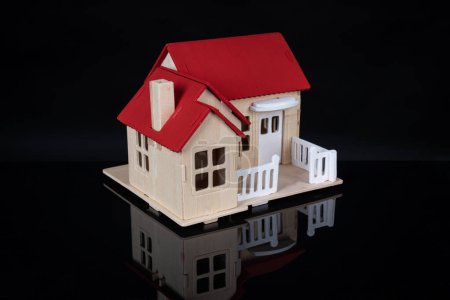 Photo for Little toy model house on black background wiyh reflection - Royalty Free Image