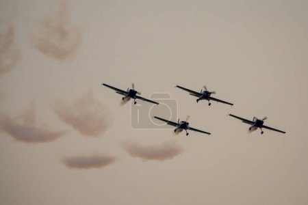 Téléchargez les photos : Quatre avions en formation en spectacle aérien. L'équipe de voltige effectue un vol au spectacle aérien - en image libre de droit