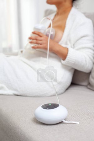 Photo for Mother pumped breast milk with electric breast pump. Mothers breasts milk for newborn baby - Royalty Free Image