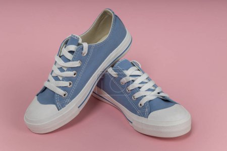 Téléchargez les photos : Paire de nouvelles baskets bleues, chaussures de sport sur fond rose. - en image libre de droit
