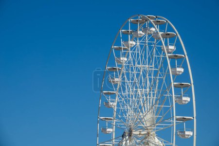 Foto de Rueda Ferris blanca grande y alta. Rueda de hurón moderna en carnaval con cielo azul - Imagen libre de derechos