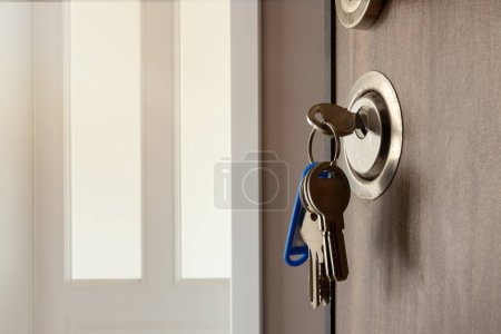 Téléchargez les photos : Ouvrez la porte d'une nouvelle maison. Poignée de porte avec clés. Hypothèque, investissement, immobilier, immobilier et concept de maison neuve - en image libre de droit