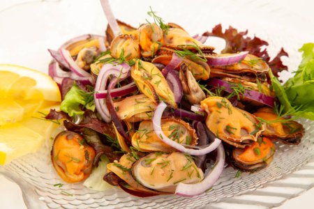 Téléchargez les photos : Salade aux moules et oignon sur une assiette en verre au citron - en image libre de droit