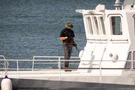 Téléchargez les photos : Terroriste avec mitrailleuse sur un navire détourné - en image libre de droit
