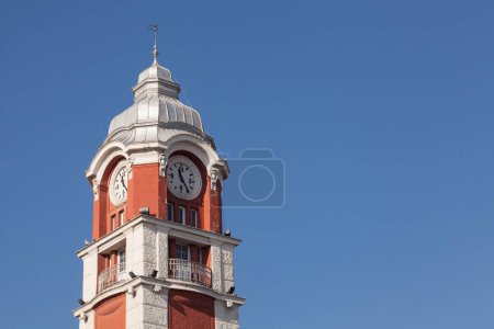 Foto de Torre del reloj de la estación de tren de Varna, contra el cielo azul. Detalle de la arquitectura de Varna, la capital del mar de Bulgaria. - Imagen libre de derechos