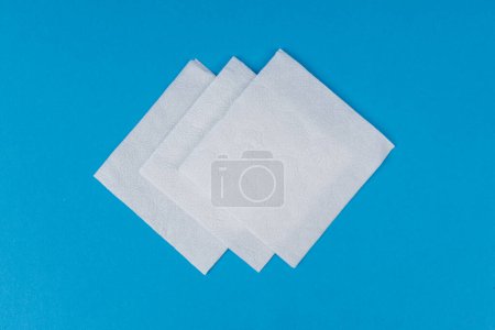 Téléchargez les photos : Serviettes en papier blanc sur fond bleu - en image libre de droit