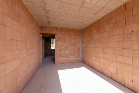Téléchargez les photos : Chambre inachevée intérieur du bâtiment en construction. Murs rouges brique. Nouvelle maison. - en image libre de droit