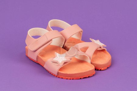 Photo for Two pink sandals on purple background. Cute pink sandals for little girl. - Royalty Free Image