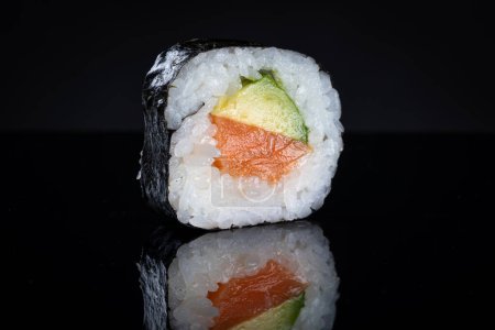 Téléchargez les photos : Rouleau de sushi au thon et à l'avocat. Sushi avec réflexion. Nourriture japonaise traditionnelle - en image libre de droit