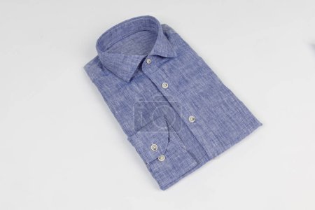 Foto de Camisa clásica de algodón plegado azul de los hombres. camisa doblada sobre fondo blanco - Imagen libre de derechos