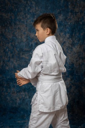 Photo for Boy in fighting position in white kimono. Aikdo - Royalty Free Image