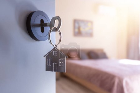 Photo for Open door to a new home with key and home shaped keychain. Mortgage, investment, real estate, property and new home concept - Royalty Free Image