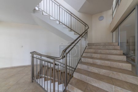 Téléchargez les photos : Escalier moderne entre les étages. Escaliers avec rail métallique dans un bâtiment moderne - en image libre de droit