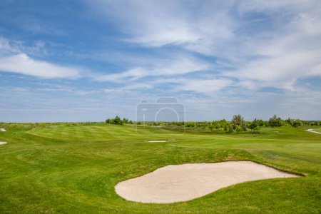 Téléchargez les photos : Terrain de golf. Champ d'herbe verte et ciel bleu nuageux - en image libre de droit