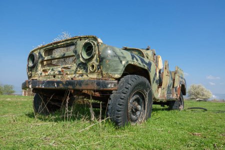 Foto de Vehículo militar abandonado y roto en el campo - Imagen libre de derechos