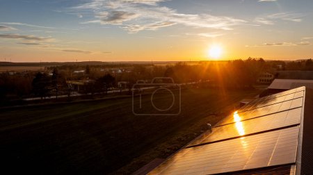 Foto de Paneles solares en el techo de un edificio. Instalación de paneles fotovoltaicos en la azotea de fábrica. Al atardecer - Imagen libre de derechos