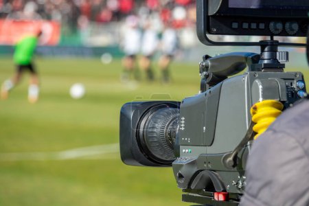 Foto de TV camera at the stadium, broadcasting during a football, soccer match - Imagen libre de derechos