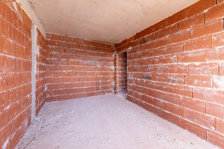 Foto de Habitación inacabada interior del edificio en construcción. Ladrillo paredes rojas. Nuevo hogar. - Imagen libre de derechos