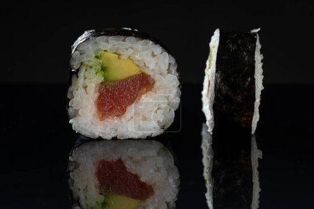 Foto de Rollos de sushi con atún y aguacate. Sushi con reflejo. Comida tradicional japonesa - Imagen libre de derechos