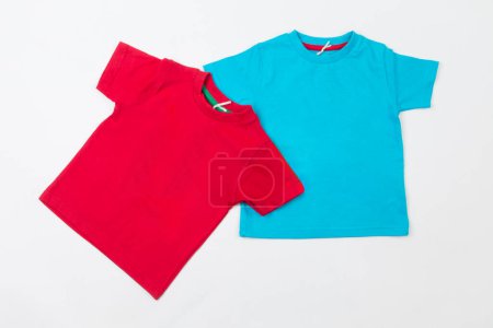Zwei leere T-Shirts auf weißem Hintergrund. Rote und blaue Kinder T-Shirts