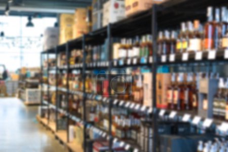 Photo for Blur shelves with wine bottles at liquor store as background with copy space. Many blurred bottles with alcohol - Royalty Free Image