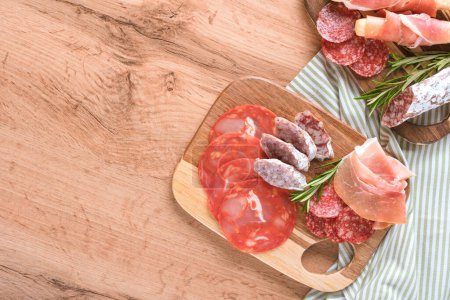 Photo for Appetizer plate, charcuterie plate with different types of sausages - salami, bresaola and proscuitto. Menu background. Traditional italian antipasti on wooden table with copy space - Royalty Free Image
