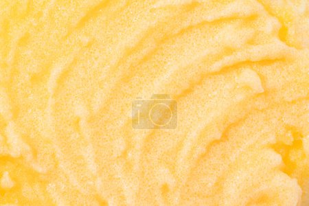 Téléchargez les photos : Sugar or salt body scrub texture. Yellow scrub - skin care product with fruit extract as cosmetic background with copy space. Macro photo - en image libre de droit