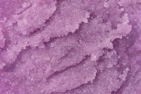 Foto de Sugar or salt body scrub texture. Purple indigo scrub - skin care product with fruit extract as cosmetic background with copy space. Macro photo - Imagen libre de derechos