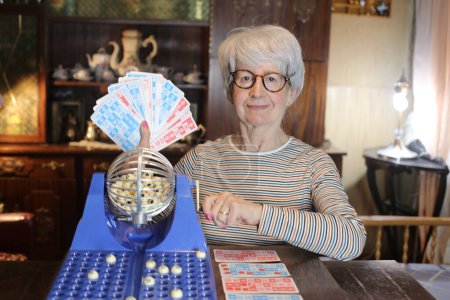Photo for Close-up portrait of mature woman with lotto game at home - Royalty Free Image