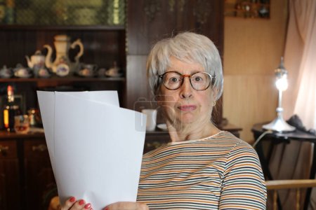 Photo for Close-up portrait of mature woman with lots of papers at home - Royalty Free Image