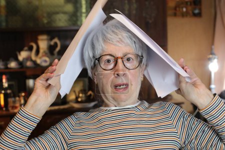 Photo for Close-up portrait of mature woman with lots of papers at home - Royalty Free Image