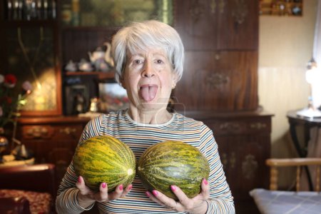 Foto de Close-up portrait of mature woman with melons at home - Imagen libre de derechos