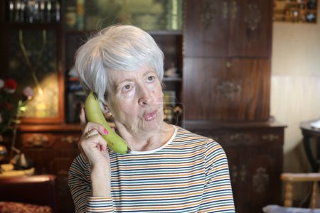 Photo for Close-up portrait of mature woman with banana at home - Royalty Free Image