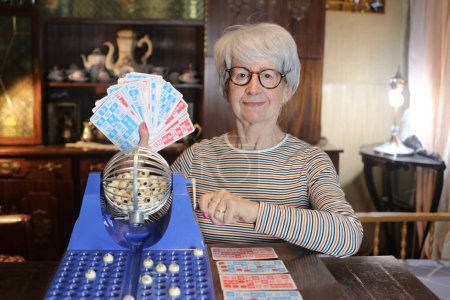 Foto de Close-up portrait of mature woman with lotto game at home - Imagen libre de derechos